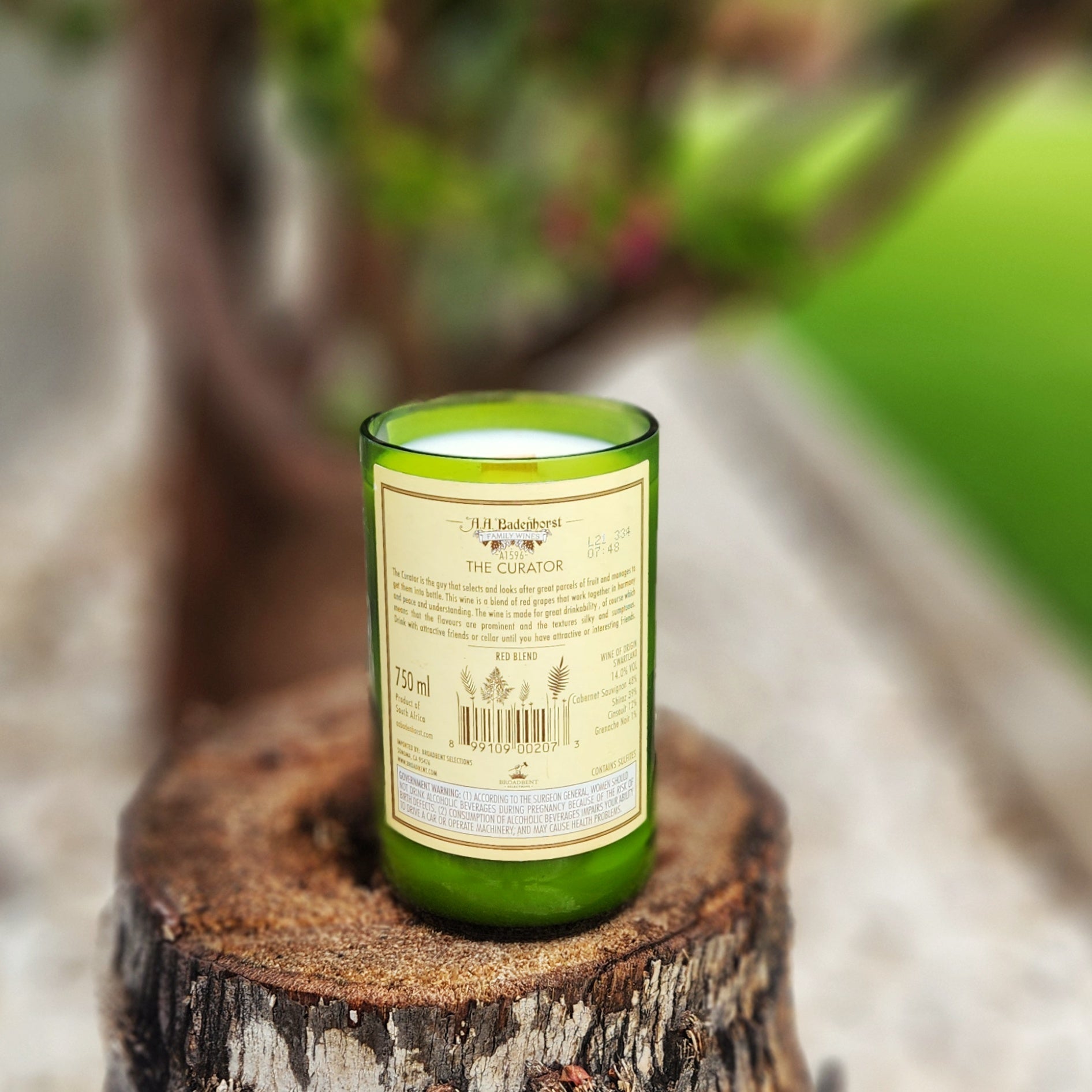 Back label view of a clean-burning wine bottle candle made from a recycled green Curator wine bottle, hand poured with coconut soy wax and a wooden wick.
