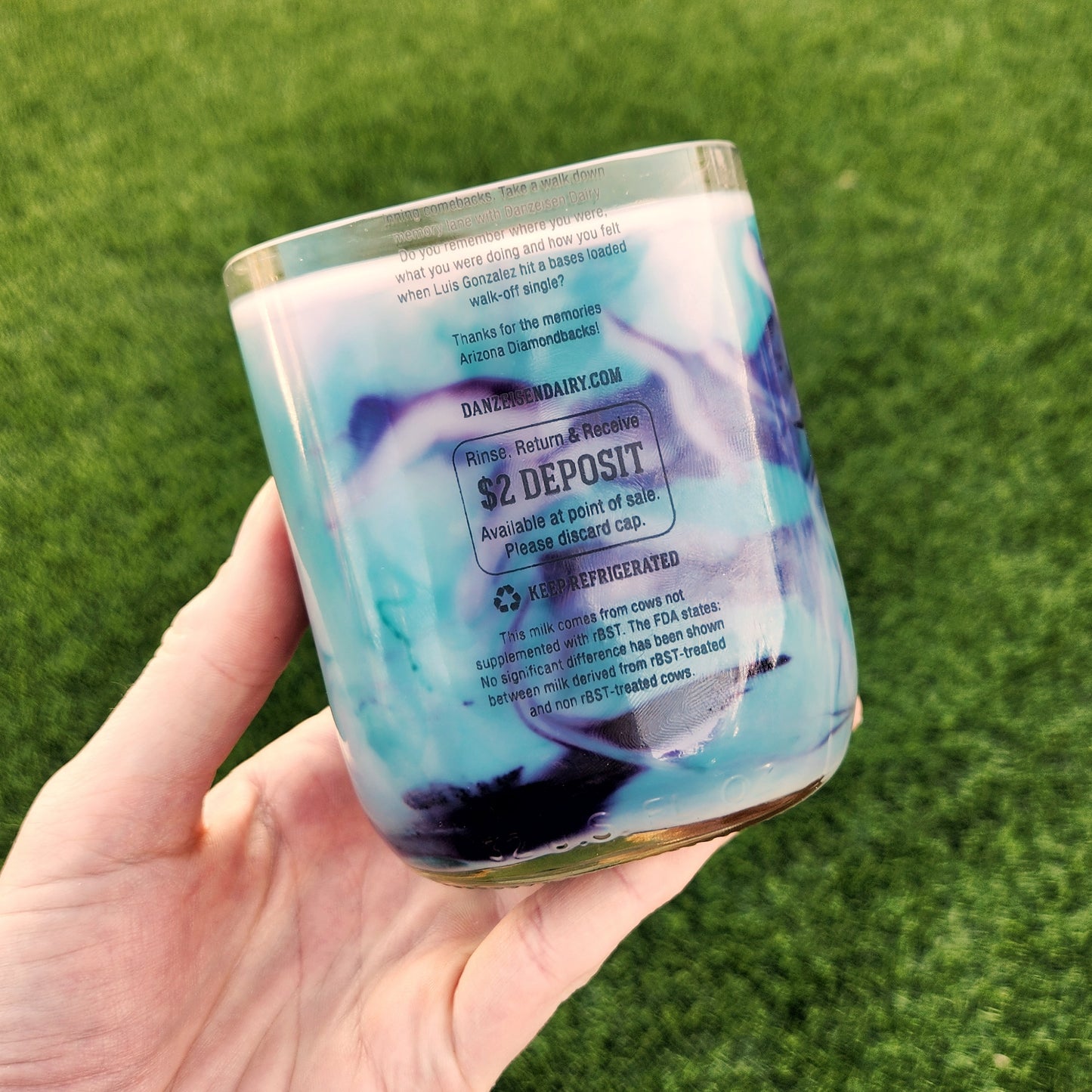 Back label of a repurposed milk bottle candle featuring Arizona Diamondbacks tribute text, highlighting sustainability and recycled packaging.