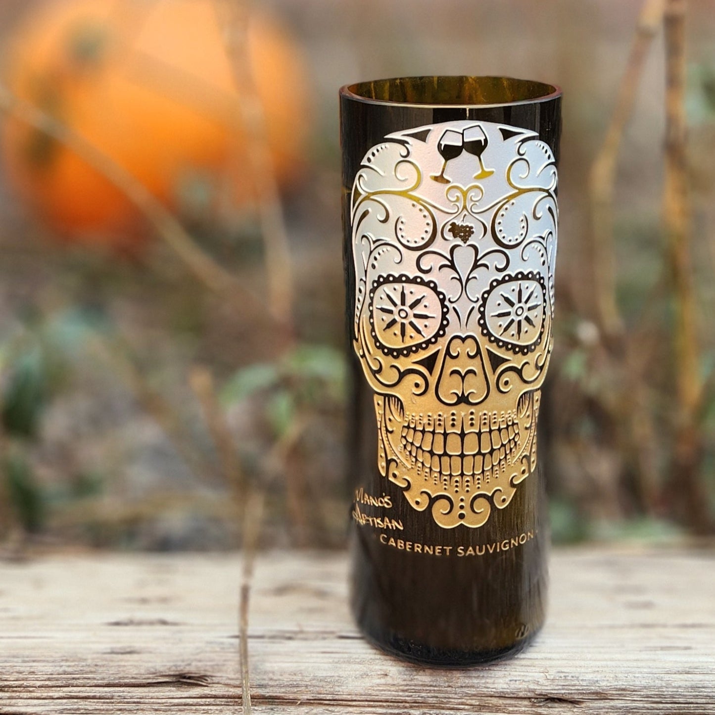 Add a touch of seasonal charm with this hand-poured candle in a recycled wine bottle. Featuring a stunning sugar skull design and set against a rustic autumn backdrop with a pumpkin, it’s perfect for celebrating fall and Día de los Muertos