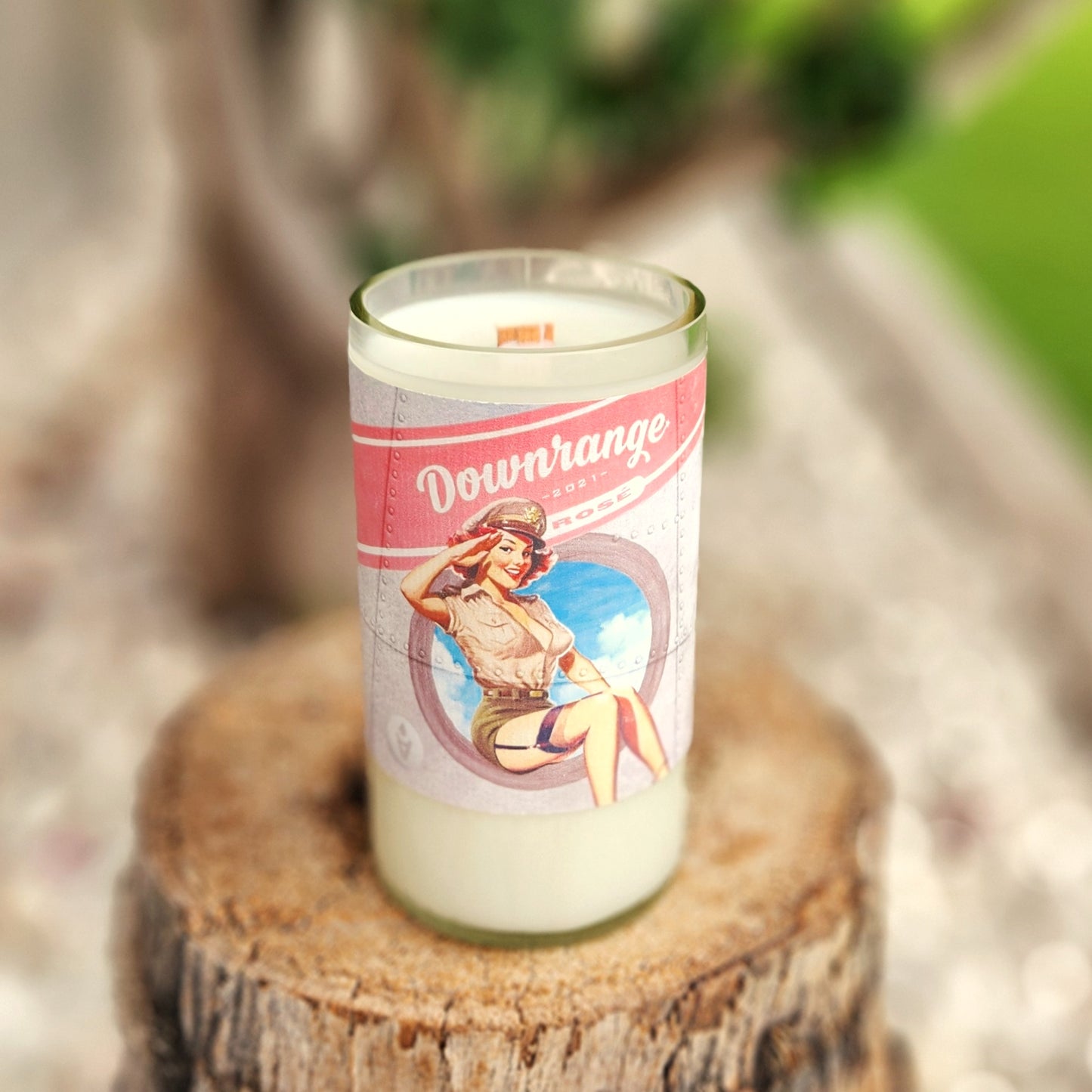 Hand-poured coconut soy wax candle in a clear-cut recycled wine bottle with a vintage-style pink and blue pin-up label. Features a wooden wick and polished rim for a clean, even burn. The classic artwork and minimalist aesthetic make this a bold, Americana-inspired eco-friendly candle.