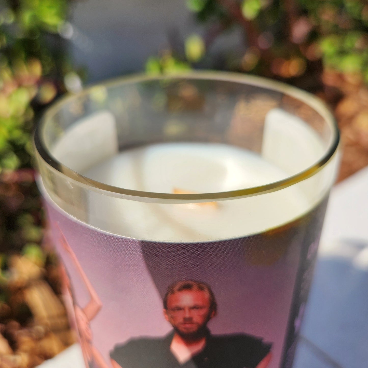 Close-up of the polished glass rim and wooden wick of a clean-burning, eco-friendly candle featuring the Dance France label.