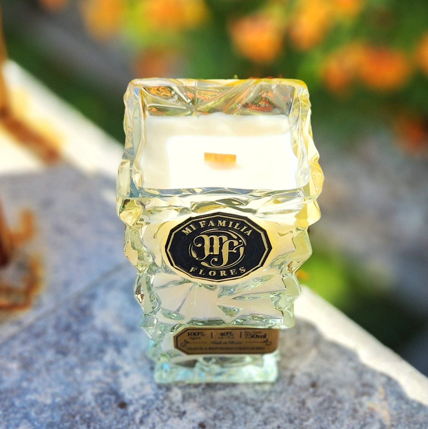 Eco-friendly candle hand-poured into a recycled Mi Familia Flores tequila bottle with sculpted crystal-style glass, creamy coconut soy wax, and a crackling wooden wick.