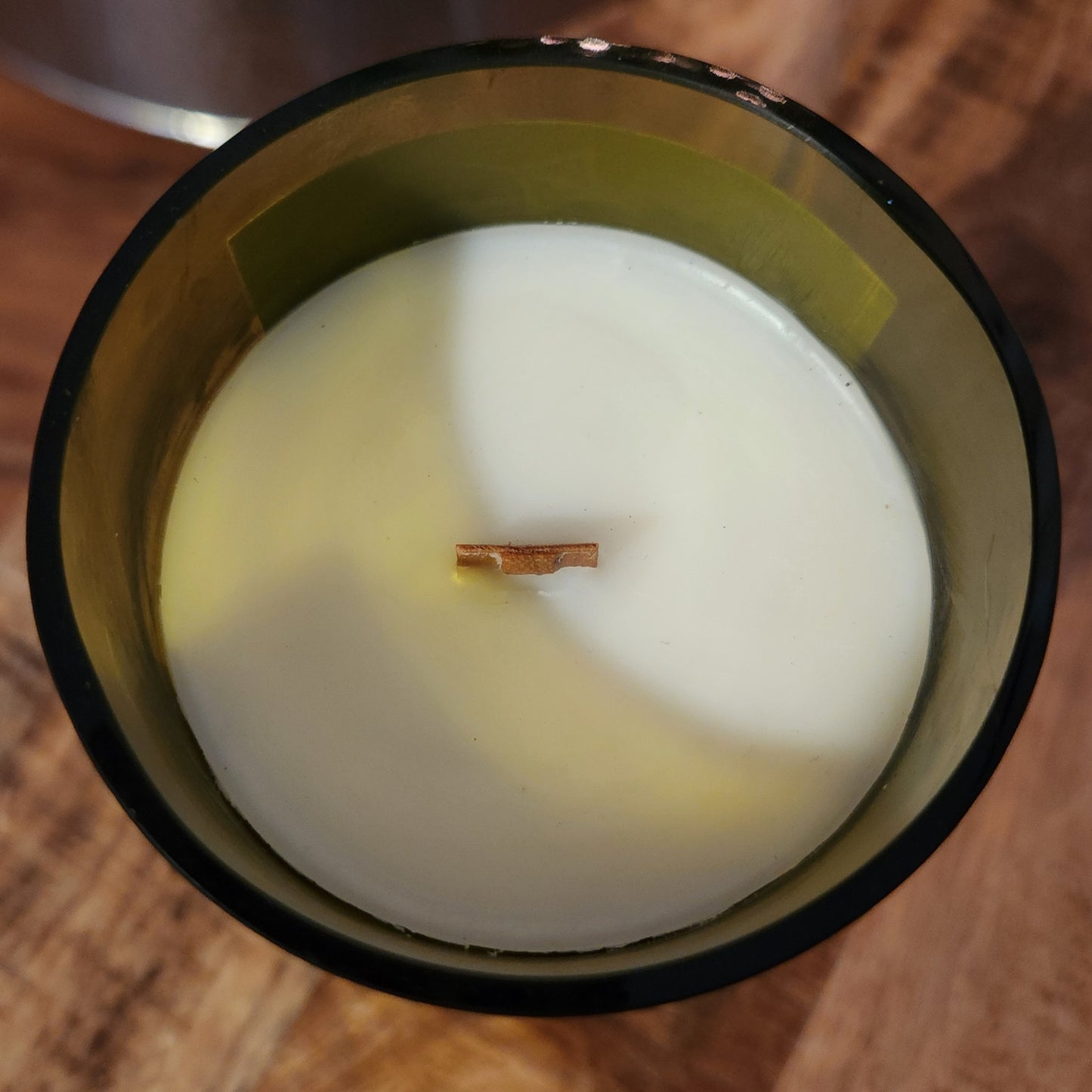 Top view of a handmade wine bottle candle crafted from a Deep Sky Vineyard bottle, featuring creamy coconut soy wax and a wooden wick for a clean, eco-friendly burn.