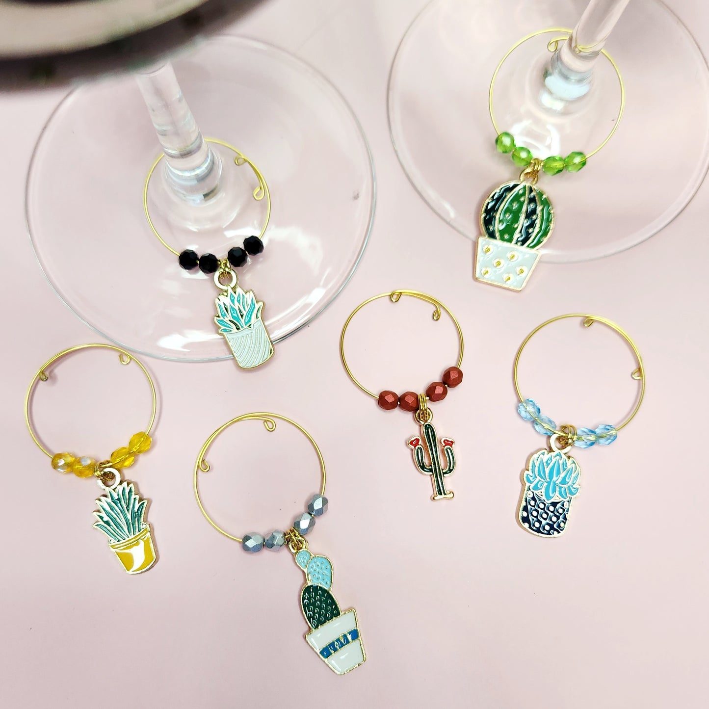 A close-up of six cactus and succulent-themed wine glass charms on wine glasses, perfect for adding a unique touch to any party or gathering.