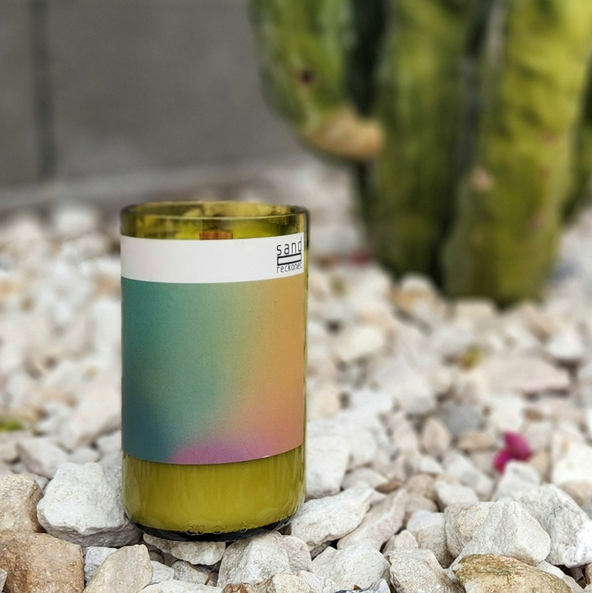 Minimalist and eco-conscious, this hand-poured candle is crafted in a recycled wine bottle with a gradient label design. Set against a desert-inspired cactus and stone backdrop, it’s a perfect blend of sustainability and modern aesthetics