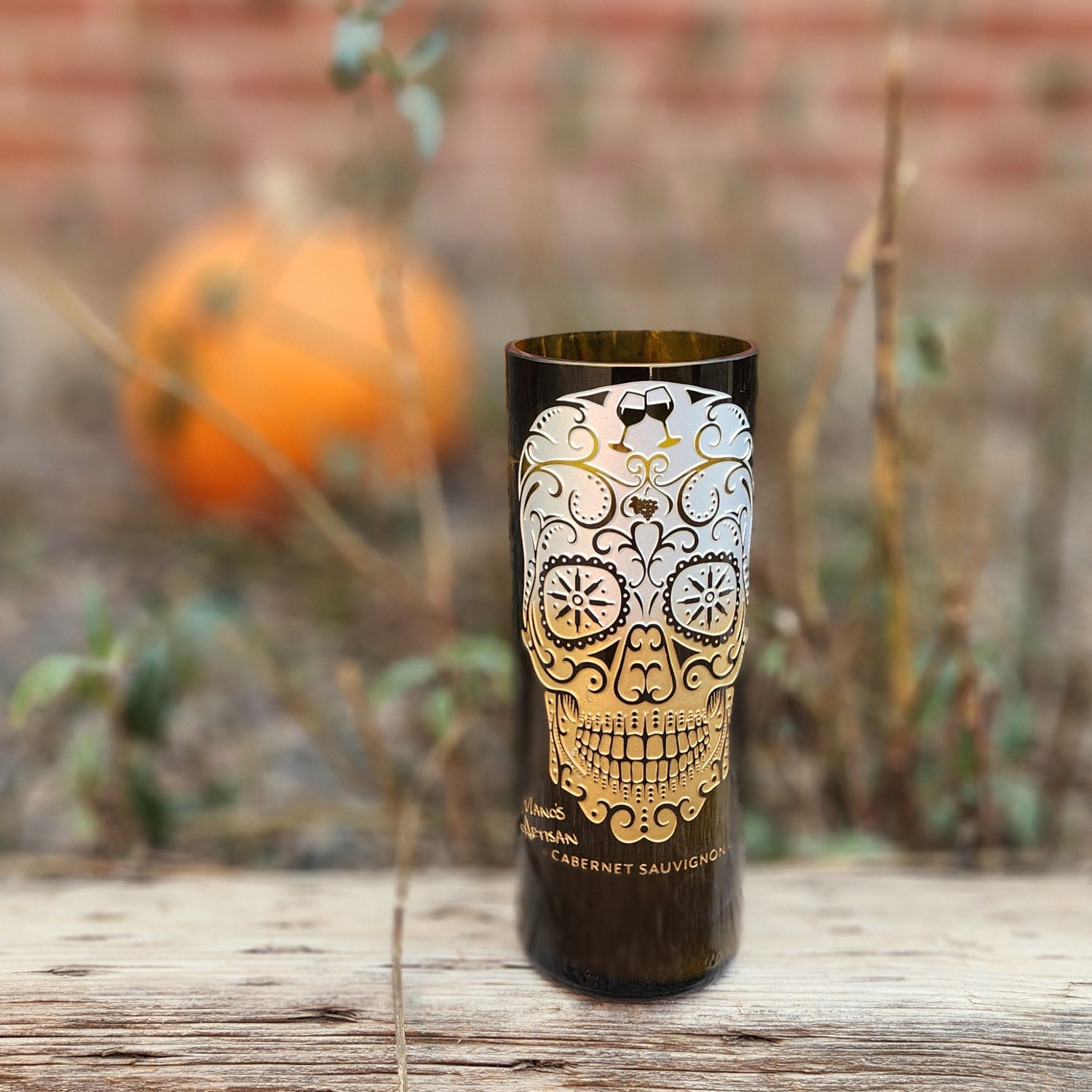 Add a touch of seasonal charm with this hand-poured candle in a recycled wine bottle. Featuring a stunning sugar skull design and set against a rustic autumn backdrop with a pumpkin, it’s perfect for celebrating fall and Día de los Muertos