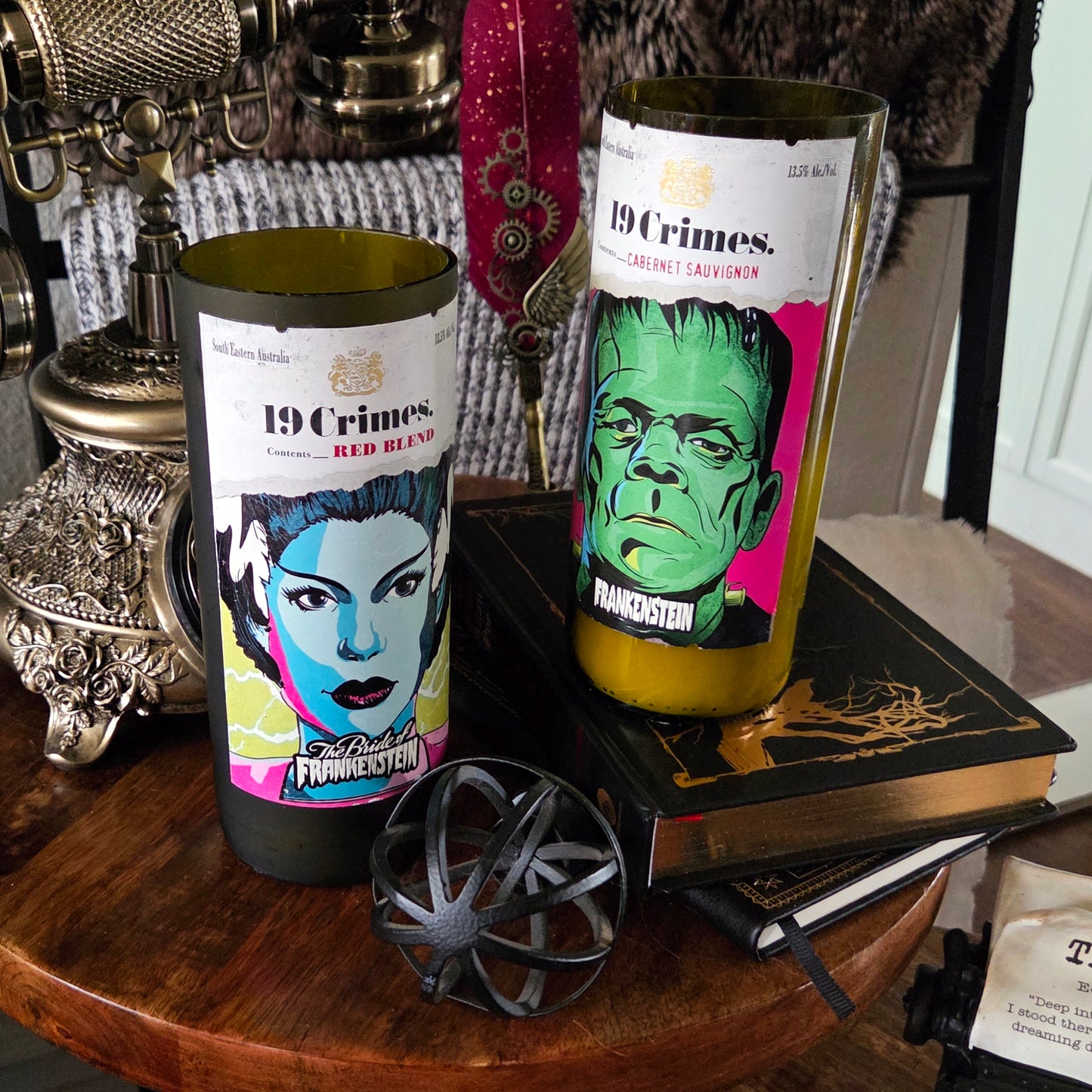 Two recycled 19 Crimes wine bottle candles displayed together—one featuring the Frankenstein label and the other the Bride of Frankenstein. Both are hand-poured with coconut soy wax and wooden wicks for a clean, eco-friendly burn.