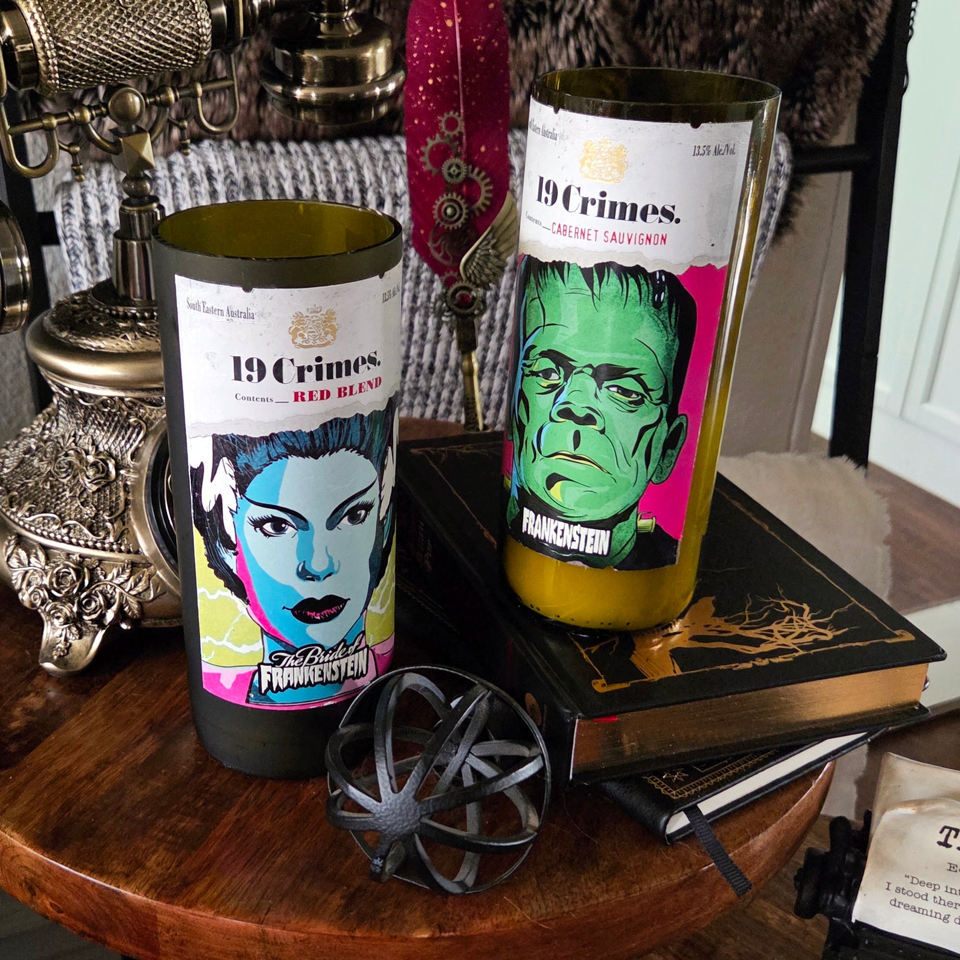 Two recycled 19 Crimes wine bottle candles displayed together—one featuring the Frankenstein label and the other the Bride of Frankenstein. Both are hand-poured with coconut soy wax and wooden wicks for a clean, eco-friendly burn.