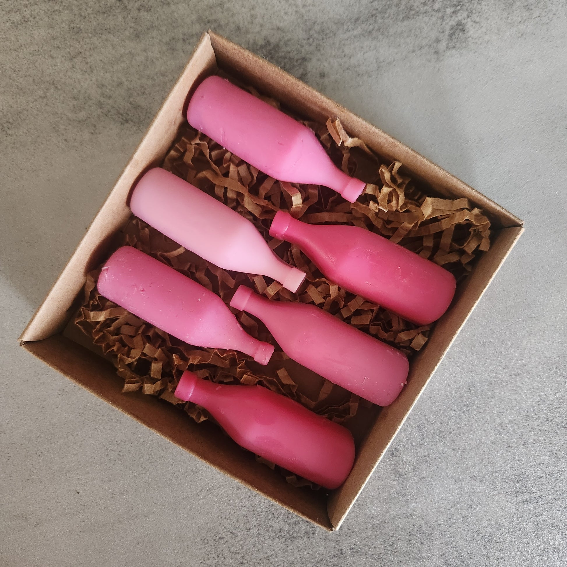 set of six "Strawberry Wine" scented wax melts in wine bottle shapes, presented in a kraft paper box.