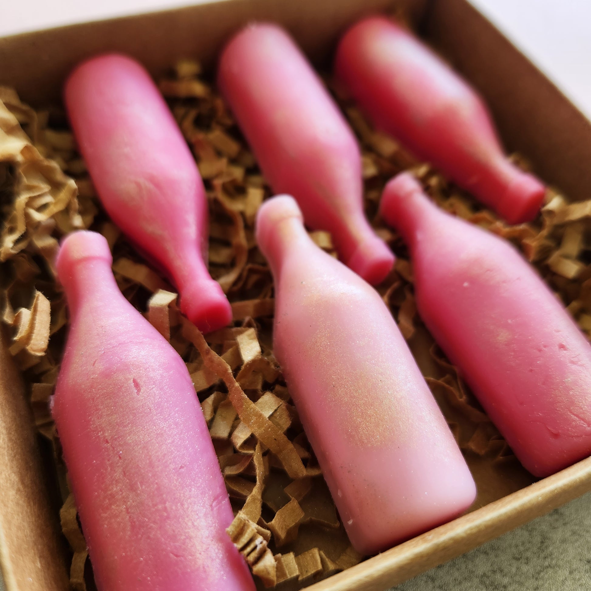 Close-up of "Strawberry Wine" wax melts with a strawberry and guava scent, emphasizing the smooth texture and vibrant pink color.