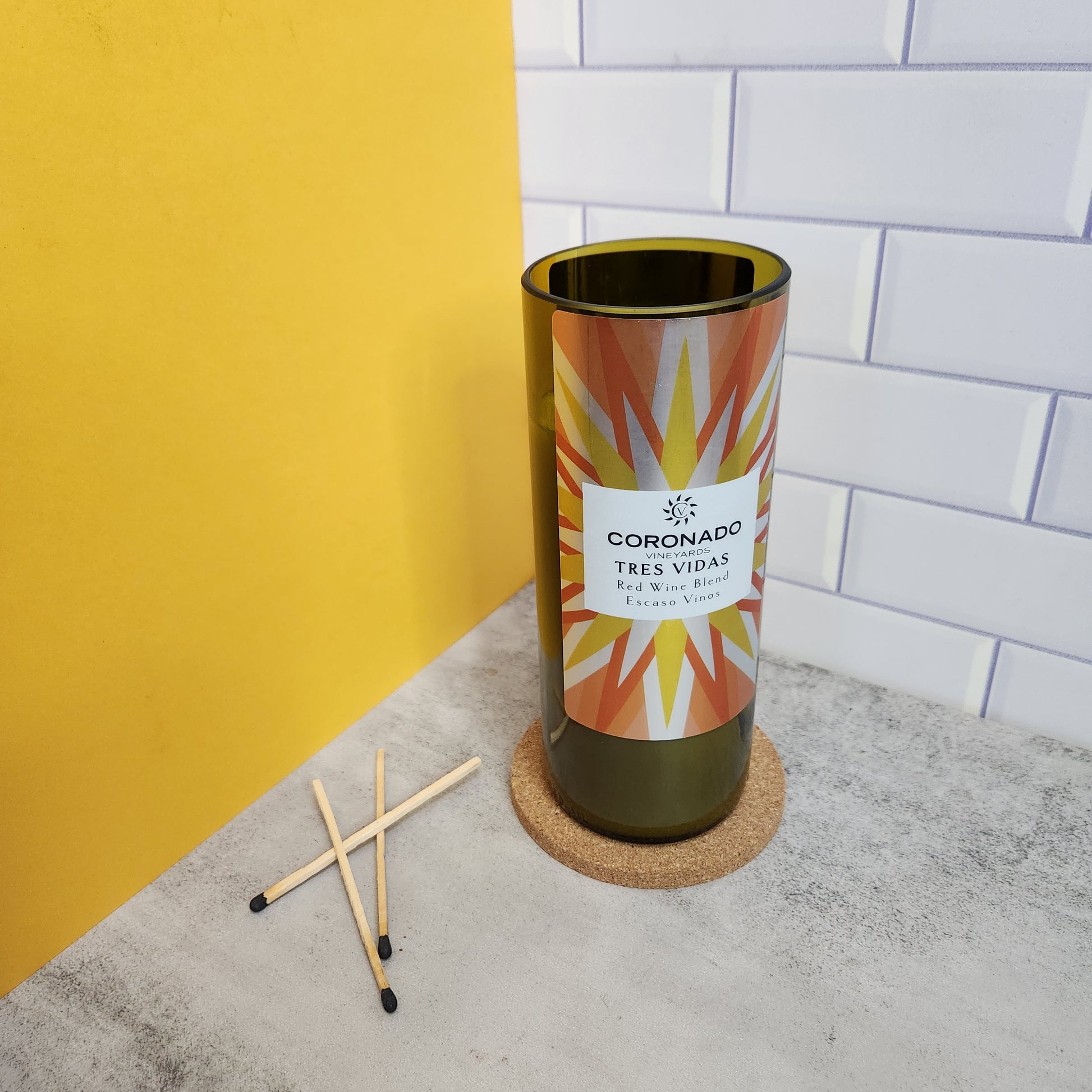 Unlit candle crafted from a recycled Coronado Vineyards Tres Vidas wine bottle with a striking geometric label, showcasing eco-friendly candle design.