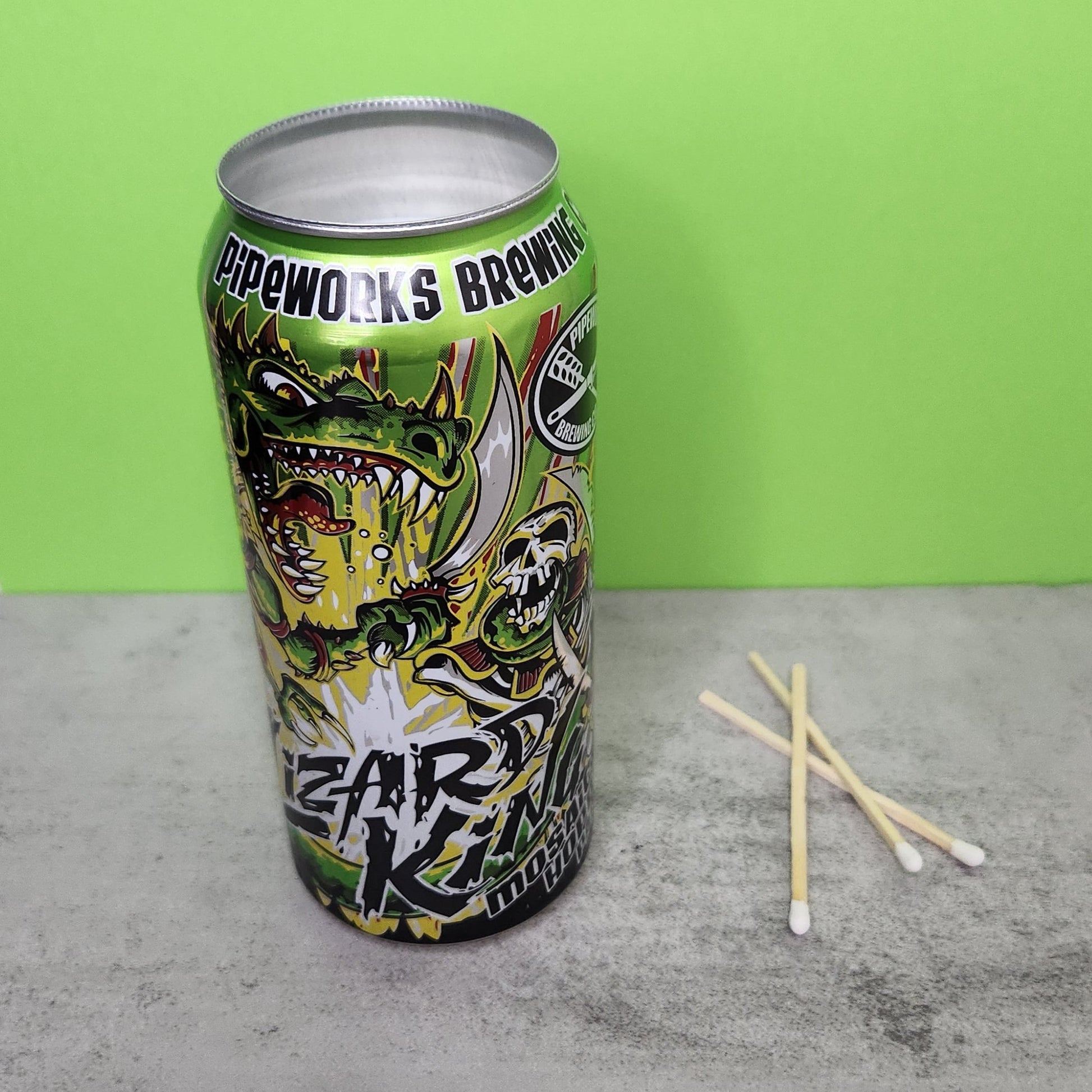 Front angle view of a Bourbon Lime scented candle in a recycled Lizard King beer can, featuring vibrant comic-style artwork and a recycled material design, perfect for eco-conscious consumers.