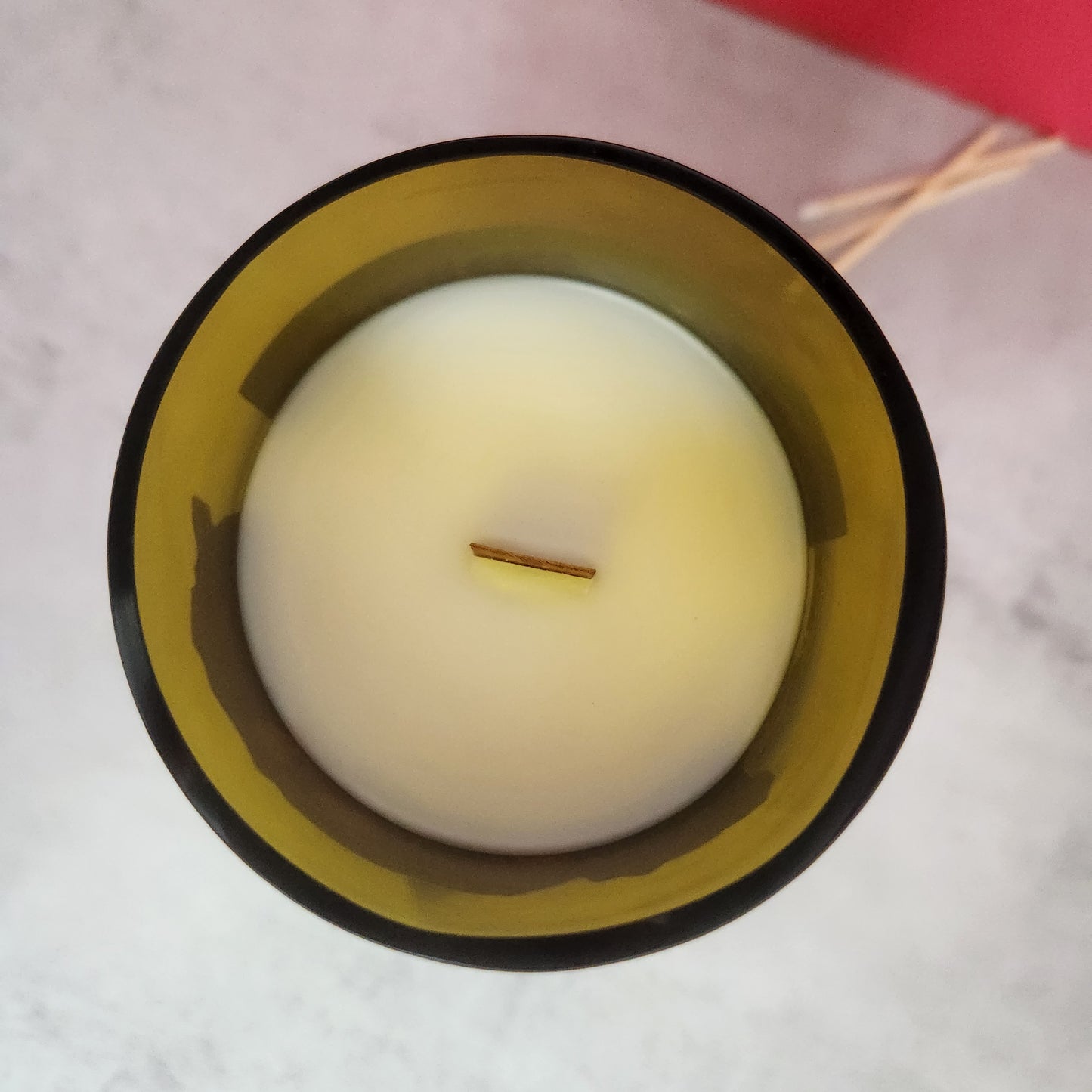 Top-down view of a white candle with a wooden wick inside a recycled wine bottle, showcasing the sustainable and hand-poured craftsmanship of Cactus+Vine candles from Phoenix, AZ.