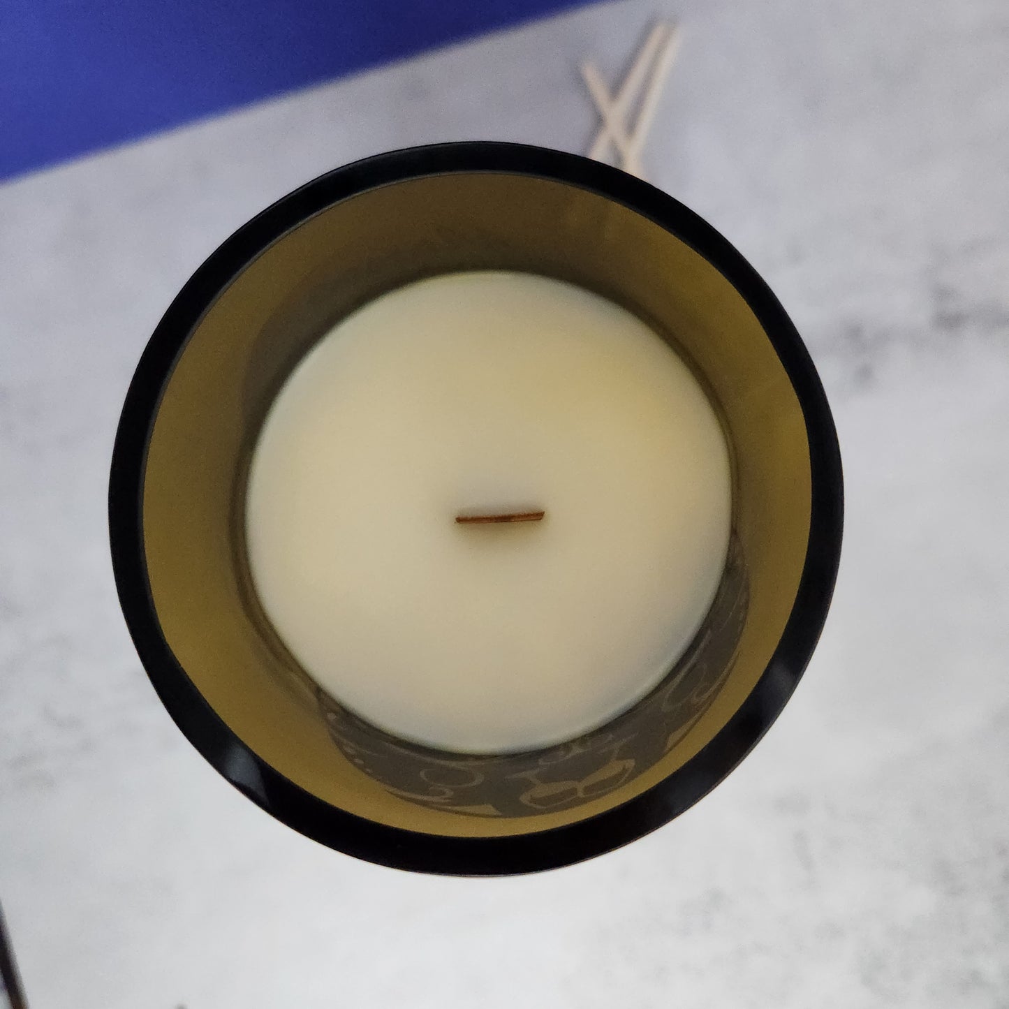 Top-down view of the Autumn Campfire candle with a wooden wick in a recycled wine bottle, illustrating the candle’s eco-friendly craftsmanship and the distinctive imperfections that make each one unique