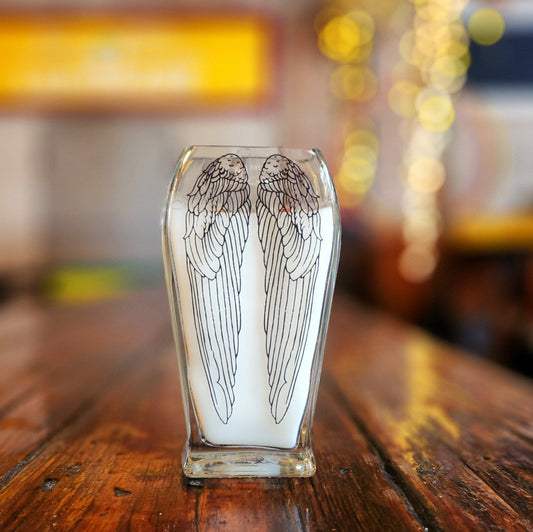 Back view of an upcycled Angel’s Envy bottle candle with an etched wing design and dual wooden wicks, capturing the artisanal charm of this eco-friendly candle made from glass.

