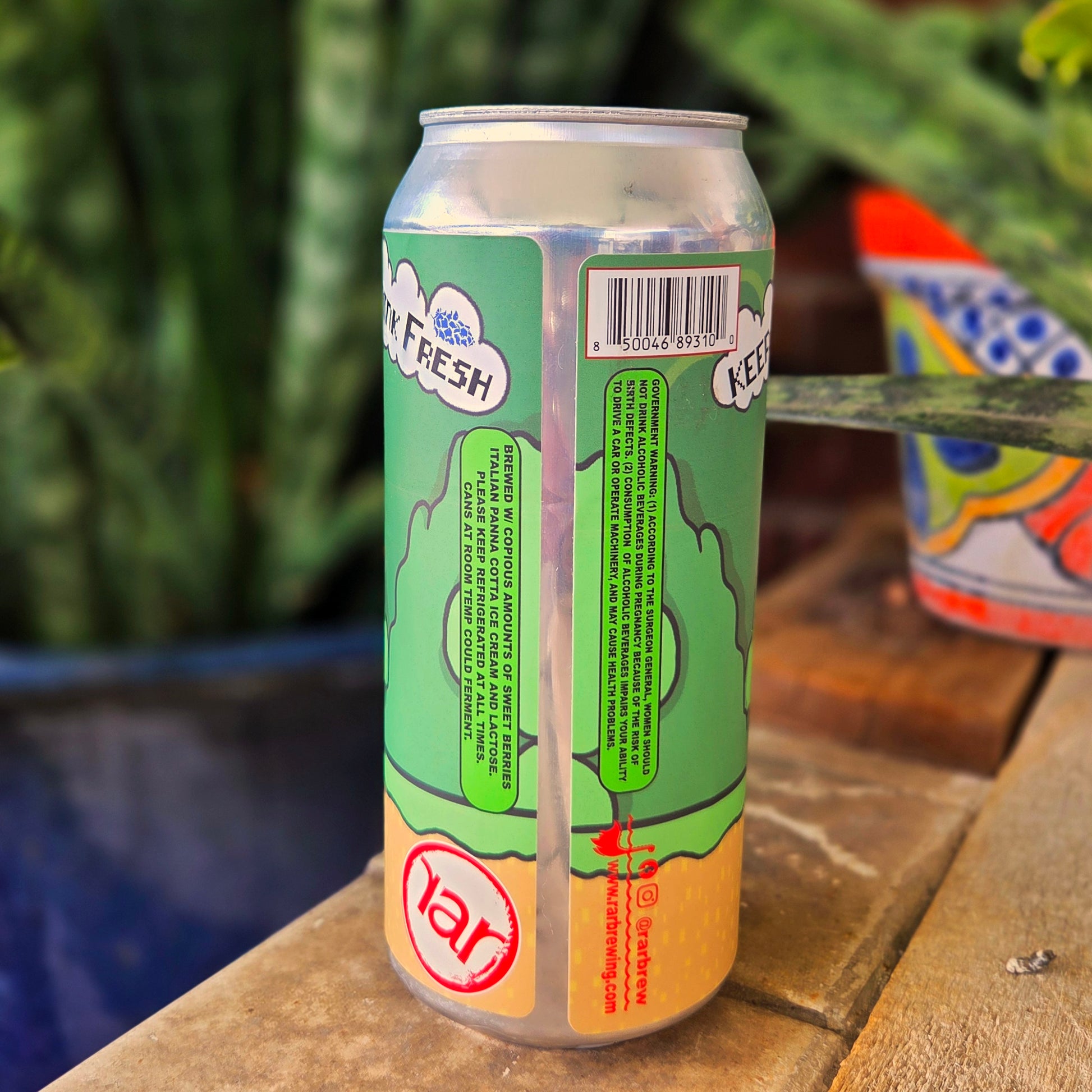 Back side of a Mario-inspired recycled beer can candle featuring a vibrant green and yellow design with brewing info and “Keep Cold, Drink Fresh” slogans. Hand-poured using coconut soy wax for a sustainable touch.