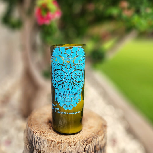 Cactus Vine’s non-toxic, coconut soy wine bottle candle set in a green bottle with vivid Day of the Dead-style blue skull design. Features a wooden wick and eco-friendly burn with a fun, collectible vessel.

