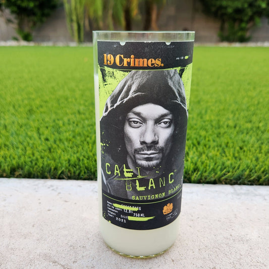 Eco-friendly candle made from a 19 Crimes Cali Blanc bottle, showcasing Snoop Dogg’s label design with a clear polished rim and creamy coconut soy wax inside.