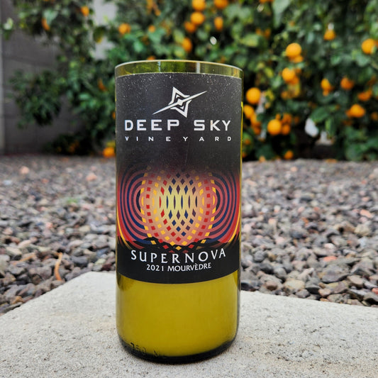 Eco-friendly wine bottle candle crafted in a recycled Deep Sky Vineyard bottle. Hand-poured with coconut soy wax, perfect for cozy home decor.