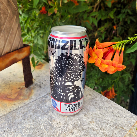 PBR can featuring art of Godzilla saying Attack Peter made into a candle, sitting outdoors.