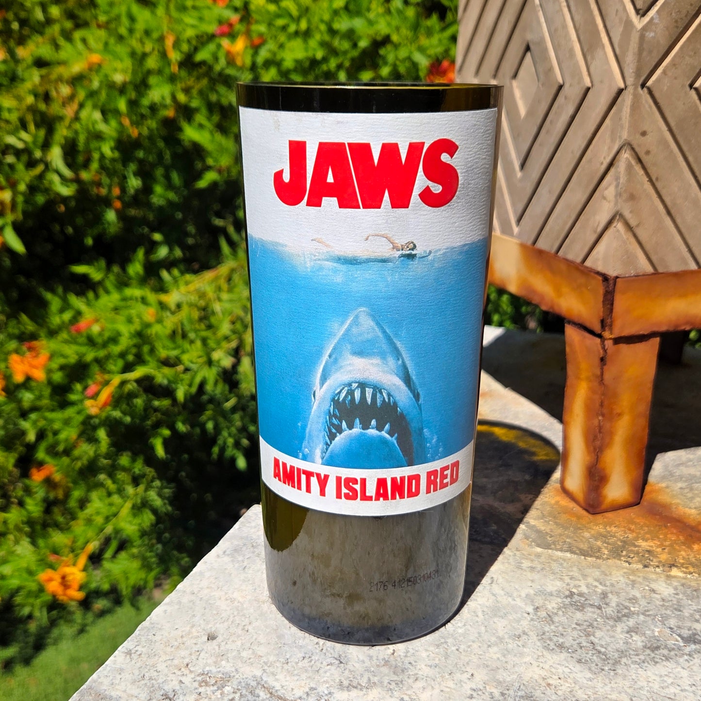 Front-facing Jaws inspired wine bottle candle with bold shark artwork and Amity Island Red label, hand-poured into a recycled bottle with coconut soy wax and wooden wick.