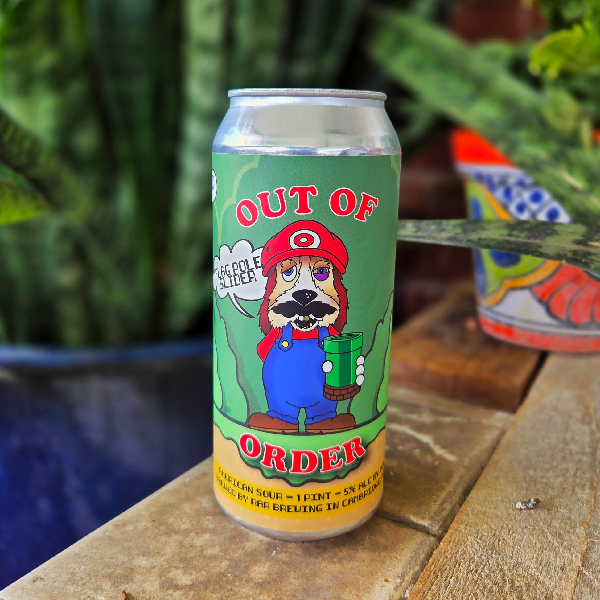 Front-facing view of an upcycled beer can candle with a cartoon dog styled after a popular video game hero. The bright green and red “Out of Order” label pops against the smooth aluminum, making this coconut soy candle a playful yet functional decor piece.