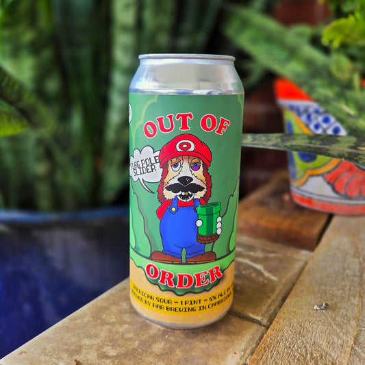 Front-facing view of an upcycled beer can candle with a cartoon dog styled after a popular video game hero. The bright green and red “Out of Order” label pops against the smooth aluminum, making this coconut soy candle a playful yet functional decor piece.