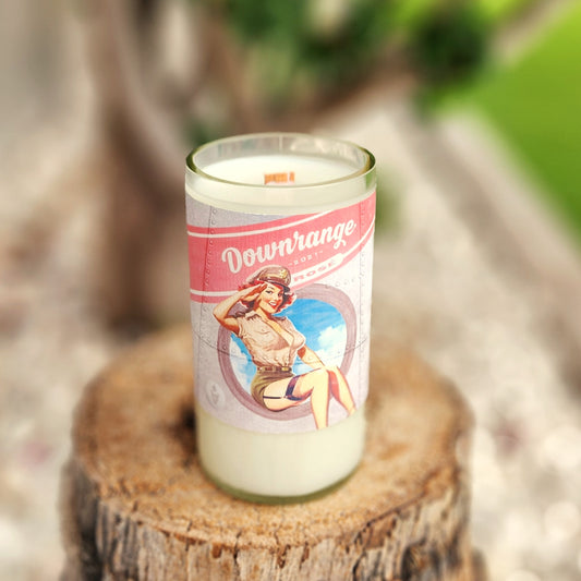 Hand-poured coconut soy wax candle in a clear-cut recycled wine bottle with a vintage-style pink and blue pin-up label. Features a wooden wick and polished rim for a clean, even burn. The classic artwork and minimalist aesthetic make this a bold, Americana-inspired eco-friendly candle.
