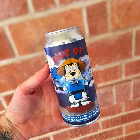Hand holding a recycled beer can candle with a Mortal Kombat-inspired Raiden cartoon dog label. The design features a straw hat, electric blue lightning effects, and the phrase “Out of Order” in bold red letters. This eco-friendly, hand-poured coconut soy wax candle with a wooden wick combines playful pop culture art with sustainable home décor.