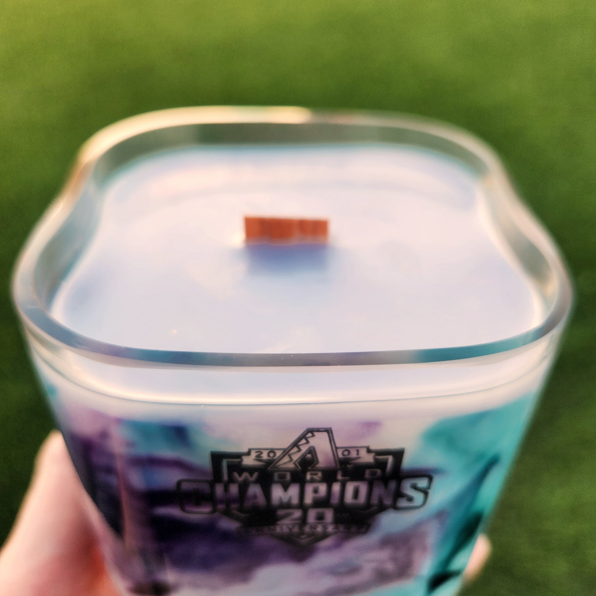 Close-up of wooden wick and smooth rim of an upcycled Arizona Diamondbacks milk bottle candle with hand-poured coconut soy wax.
