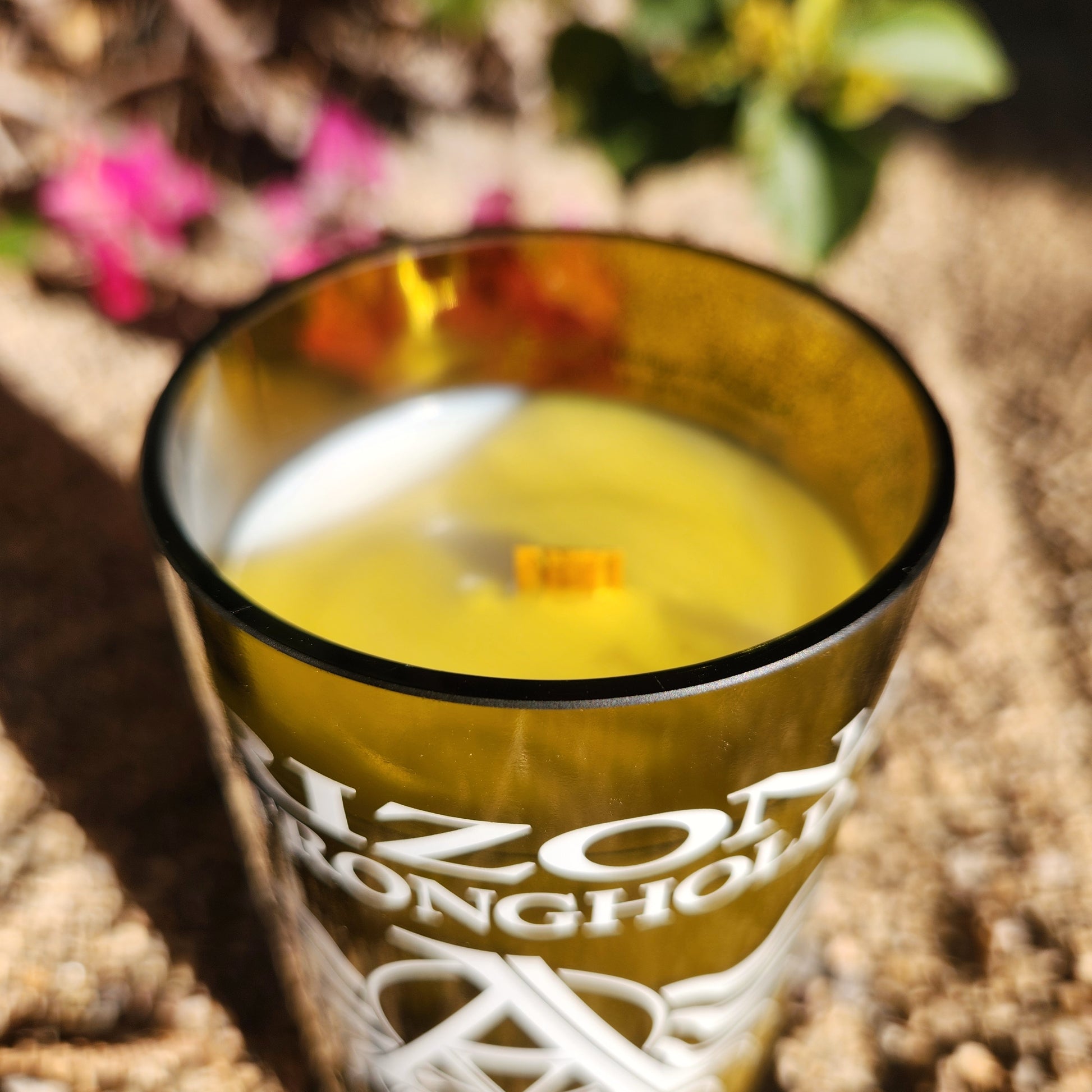 Rim view of a handcrafted eco-friendly candle made with coconut soy wax and a wooden wick. Poured into a recycled Arizona Stronghold wine bottle with crisp white wax and smooth glass edge.