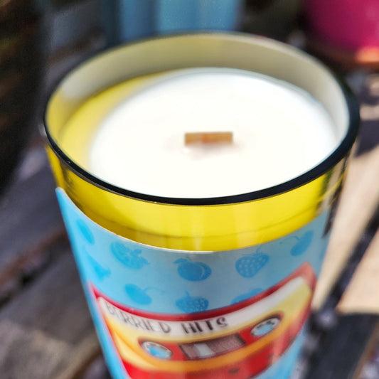 Close-up of a wooden wick peeking through smooth white coconut soy wax inside a recycled Twisted Union wine bottle candle. This eco-friendly candle features a clean, curved glass rim and colorful label design, handcrafted by Cactus Vine Candles.