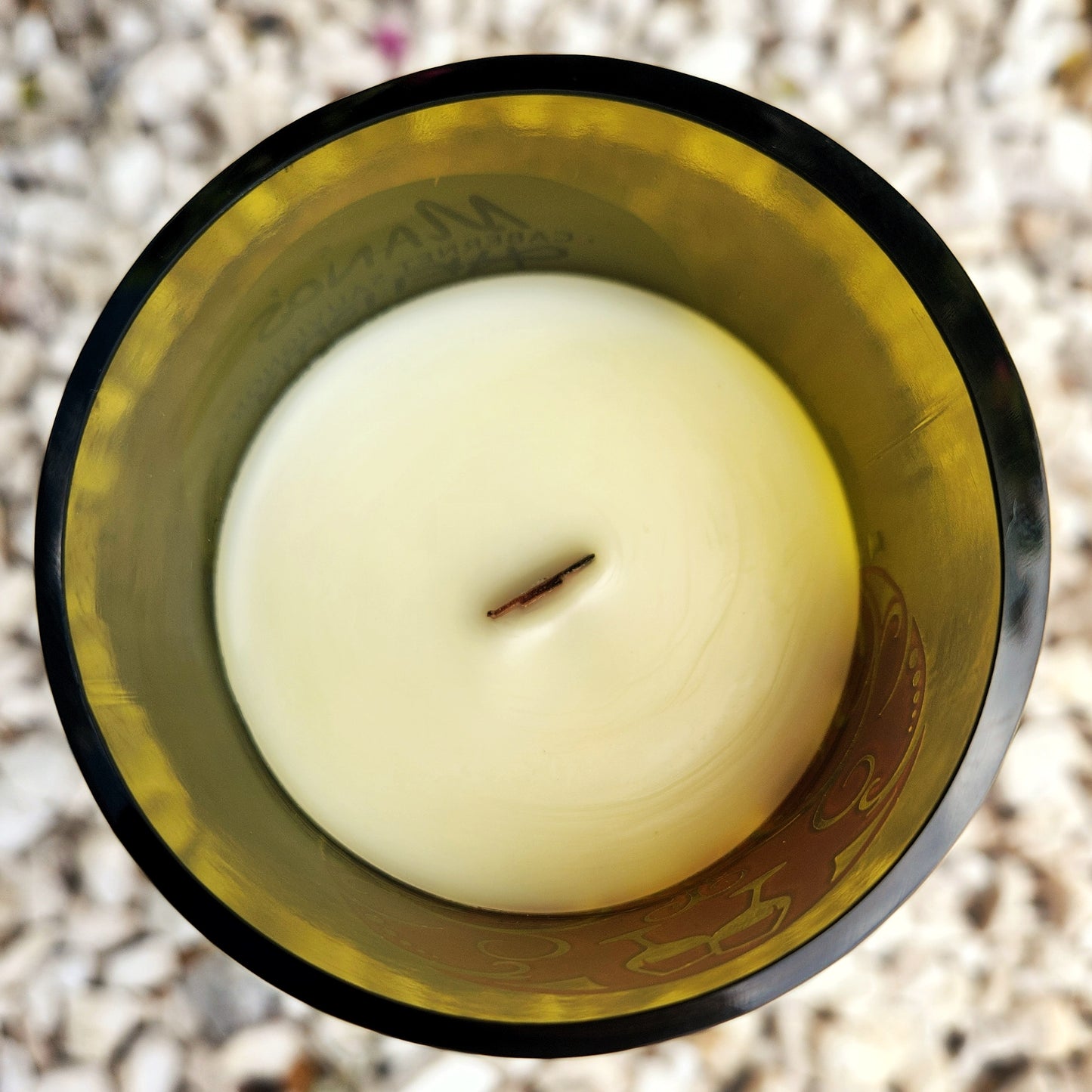 Top view of a hand-poured coconut soy candle with a wooden wick, set in an upcycled wine bottle. The smooth wax and centered crackling wick show the clean, eco-friendly burn of this sustainable wine bottle candle.