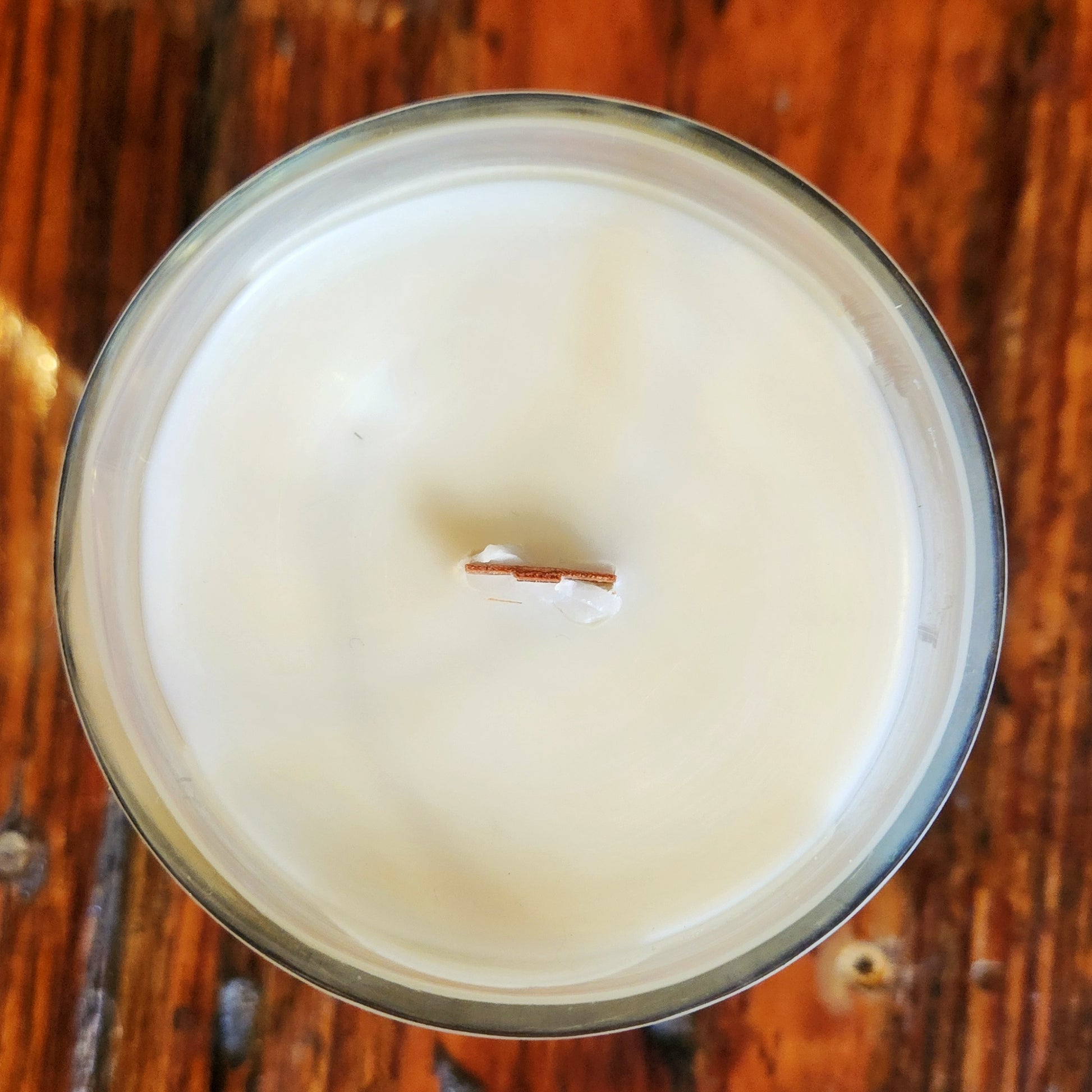  Clean-burning coconut soy wax candle viewed from above, housed in a recycled 15 Stars bourbon bottle with a centered wooden wick.