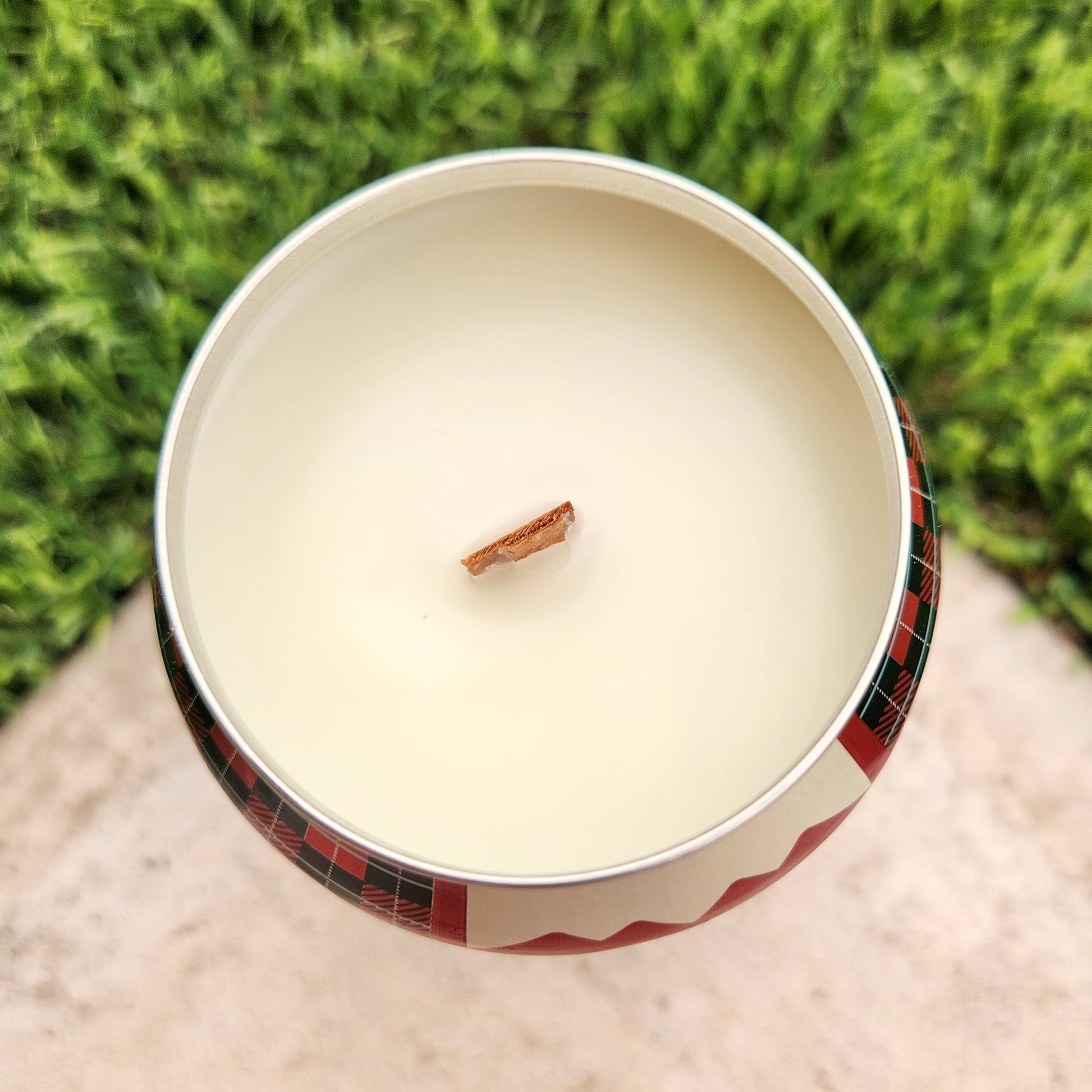 Top view of hand-poured Goldwater candle in a recycled beer can, showing smooth coconut soy wax and centered wooden wick.
