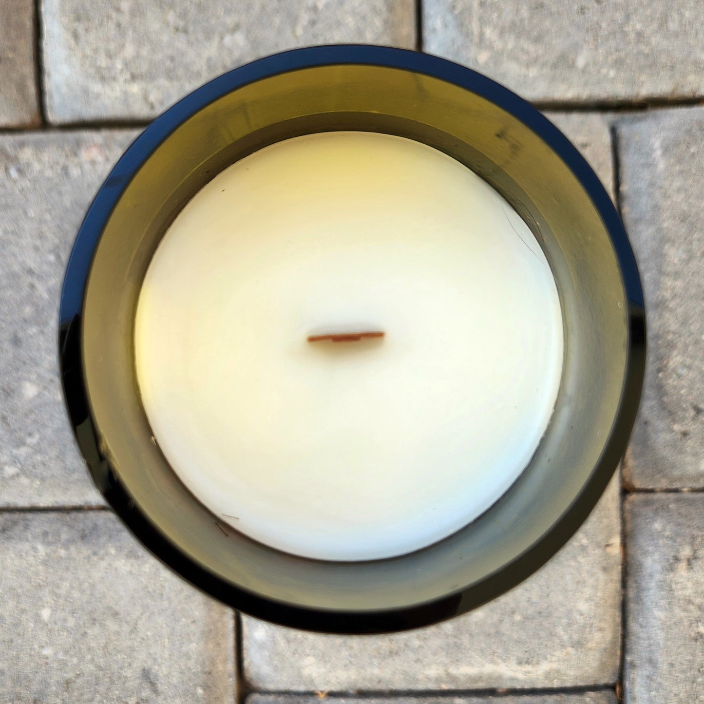 Top-down view of a clean-burning wooden wick wine bottle candle made from a Dead Zed Red wine bottle, featuring creamy white coconut soy wax with slight natural texture.