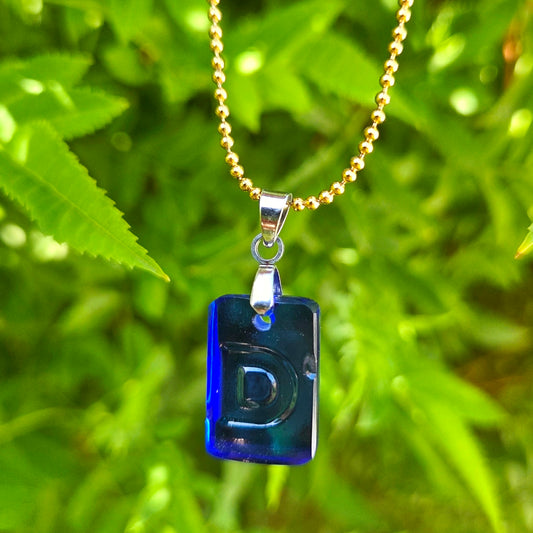 Letter D initial necklace made from blue recycled kombucha bottle glass with original recessed lettering