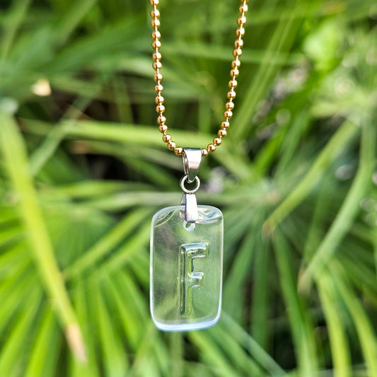Letter F initial necklace made from clear recycled liquor bottle glass with original raised lettering