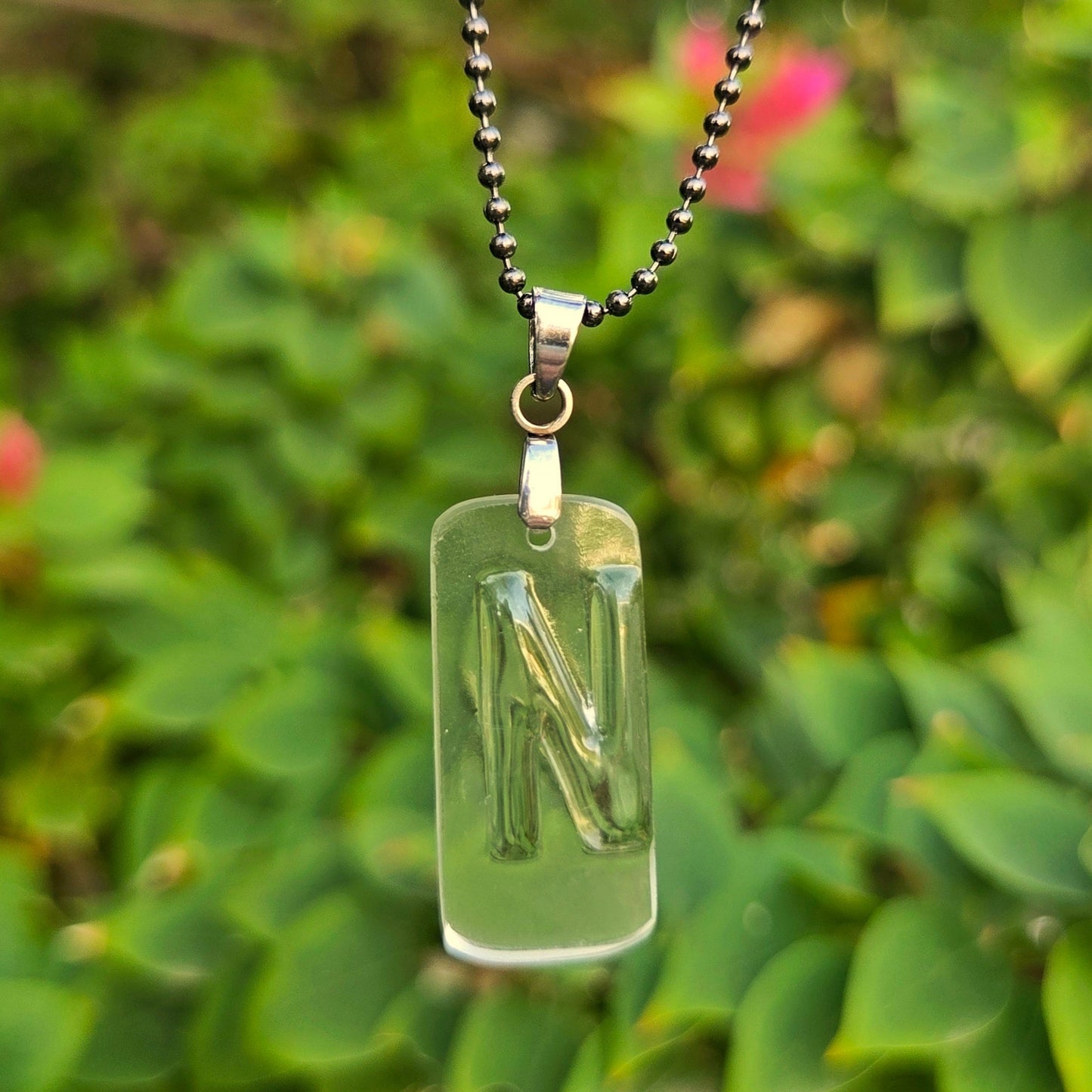 Letter N initial necklace made from clear recycled bourbon bottle glass with original raised lettering