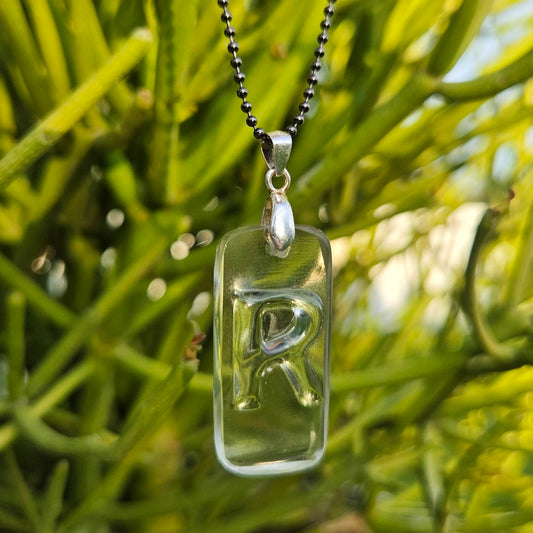 Letter R necklace made from clear recycled bourbon bottle glass with original raised lettering
