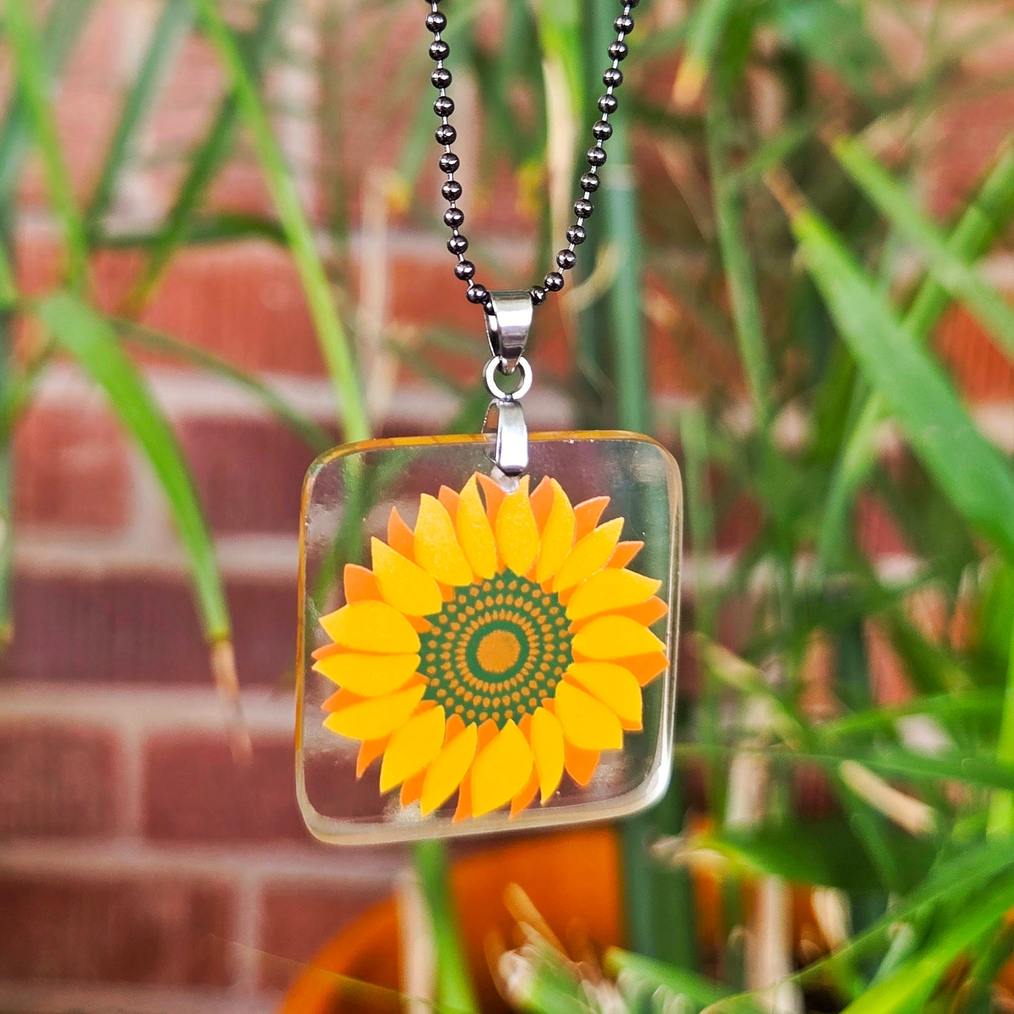 Recycled milk bottle glass sunflower pendant necklace on a gunmetal-toned ball chain