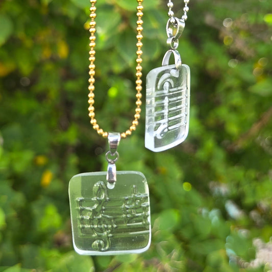 Recycled vodka bottle glass music note pendant necklaces on gold and silver ball chains.