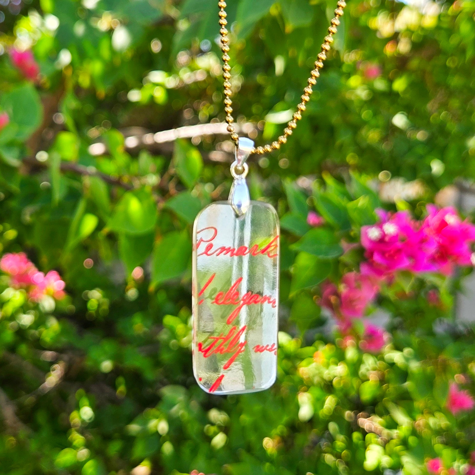 Recycled vodka bottle glass pendant with original red script lettering on a gold-tone chain