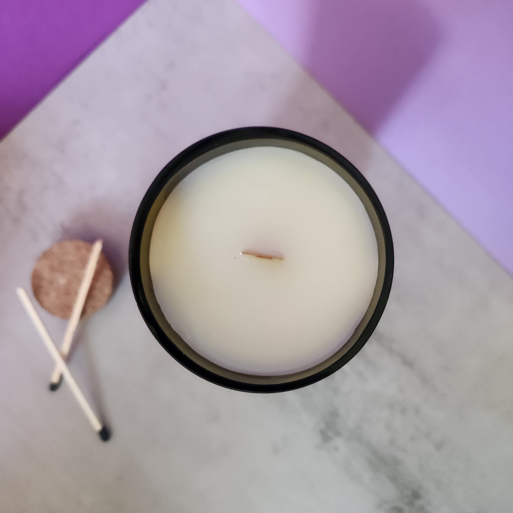 Top view of the Sage & Lavender candle, highlighting the smooth white wax surface and wooden wick inside a recycled wine bottle.