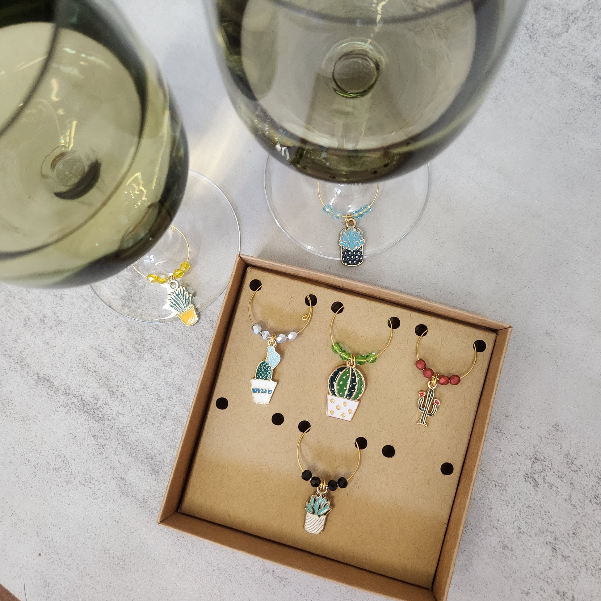 Cactus and succulent wine glass charms on display with wine glasses, highlighting their unique designs and practicality for parties.