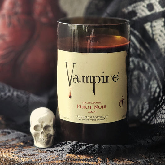 Wine bottle candle labeled 'Vampire' with a skull and dark fabric background