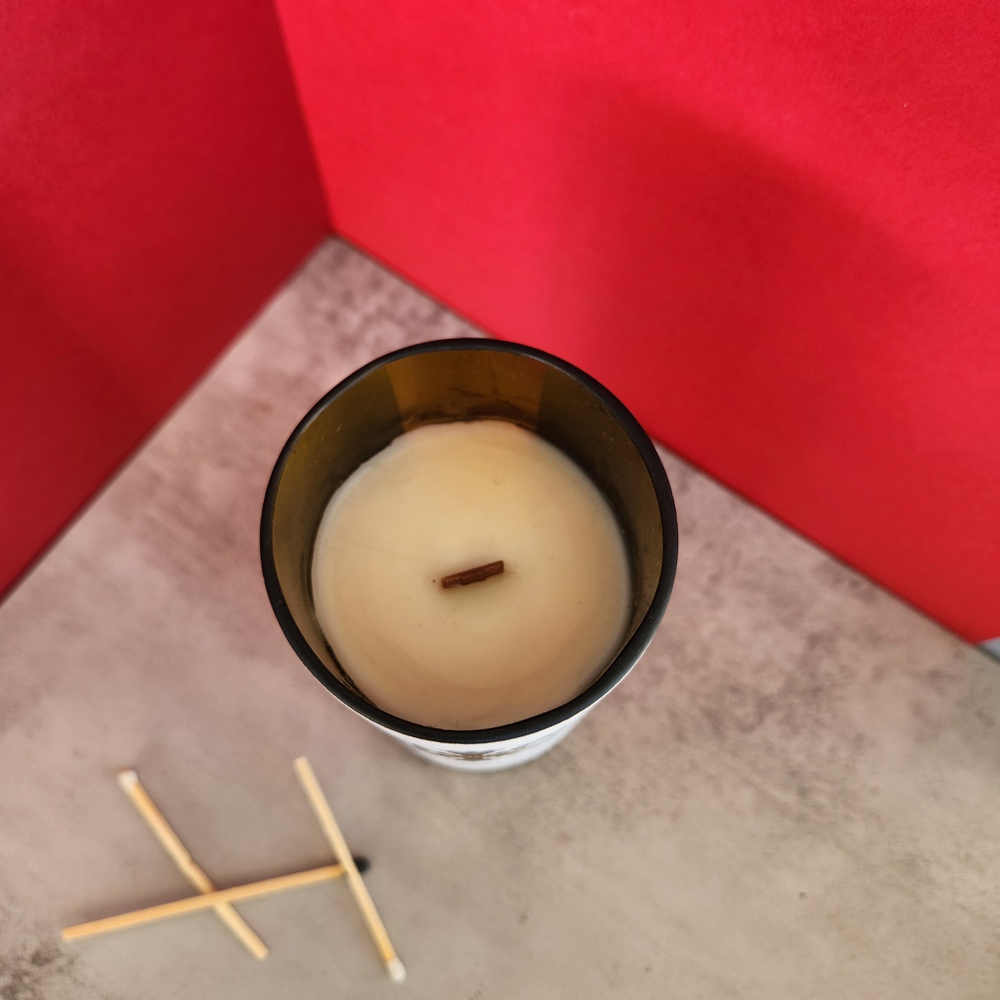 Top view of a mulled wine scented candle with a wooden wick, revealing the smooth white, creamy coconut soy wax housed in a recycled wine bottle