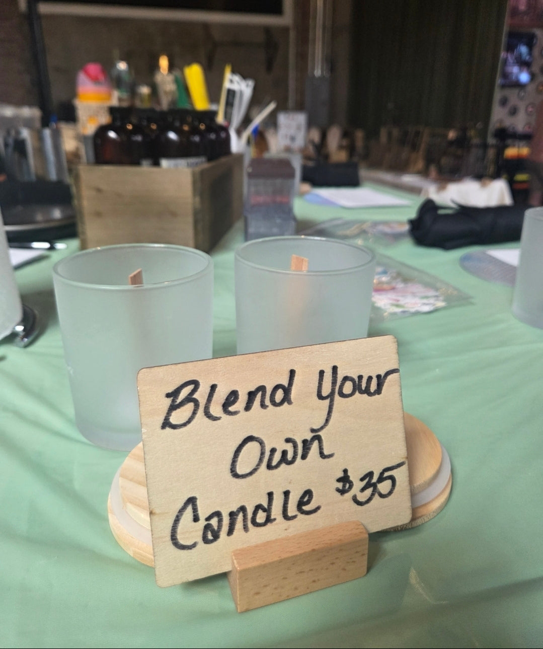 Table with candles and a sign offering 'Blend Your Own Candle' for $35.