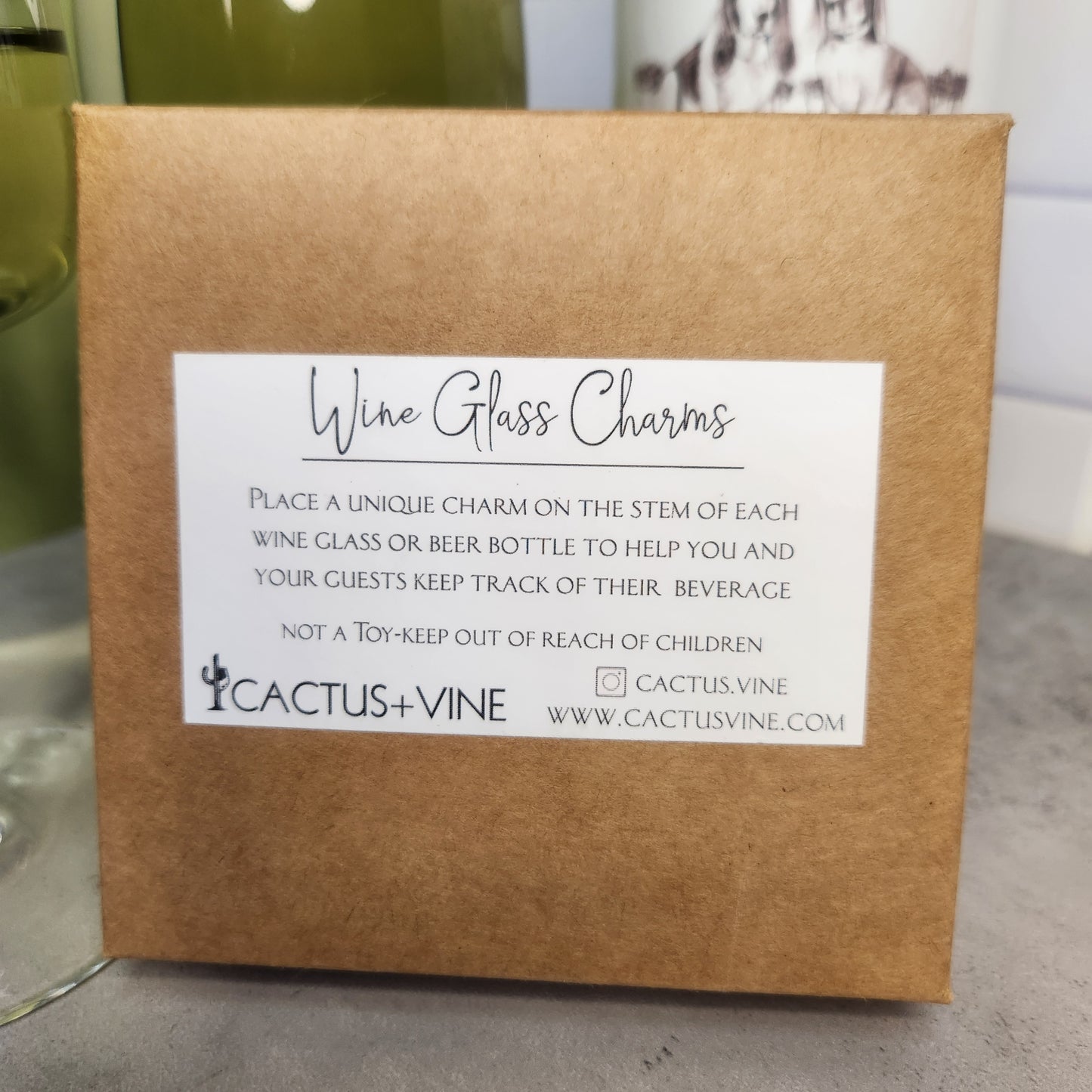 Wine Glass Charms packaging by Cactus Vine, with a label explaining the use and details of these charming wine accessories.