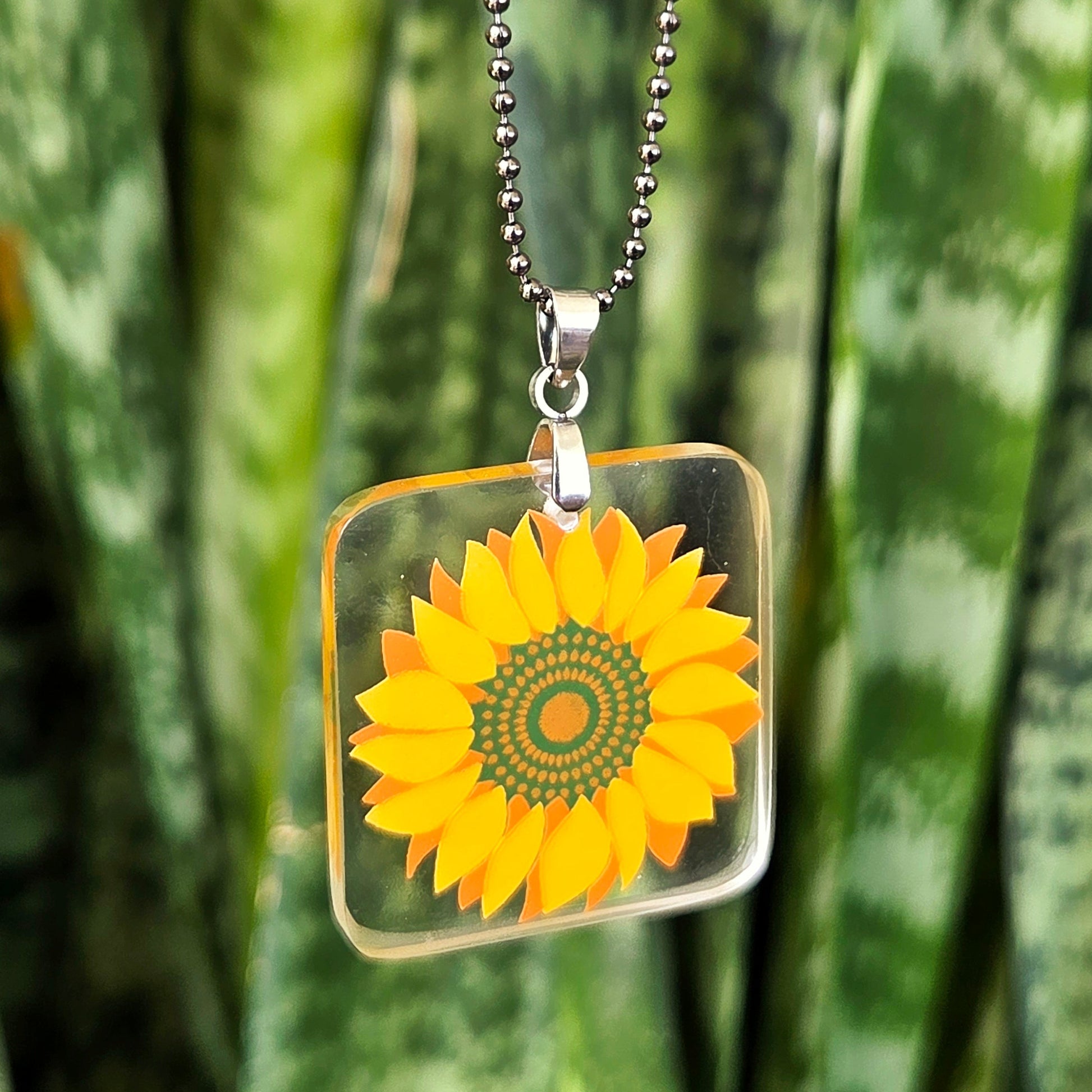 Sunflower necklace made from recycled glass milk bottle with bright yellow floral design